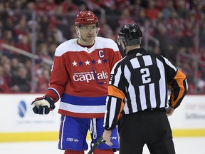 Washington Capitals left wing Alex Ovechkin (8), of Russia, talks with referee Jon McIsaac (2) during the first period of an NHL hockey game against the Carolina Hurricanes, Thursday, Dec. 27, 2018, in Washington.