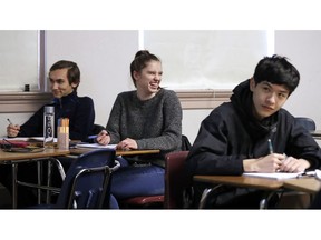 Senior Hazel Ostrowski, center, smiles as she looks up during her first period, AP statistics class at Franklin High School Wednesday, Dec. 12, 2018, in Seattle. High school students are getting more sleep in Seattle, according to a study on later school start times. Ostrowski was among a group at Franklin and another Seattle high school who wore activity monitors to discover whether a later start to the school day would help them get more sleep. It did, adding 34 minutes of slumber a night, and they reported less daytime sleepiness and grades improved.