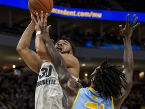 Marquette forward Ed Morrow, left, goes up for a basket against the defense of Southern University forward Bryan Assie, right, during the first half of an NCAA college basketball game Friday, Dec. 28, 2018, in Milwaukee.