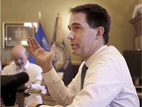 FILE - In this Nov. 15, 2018, file photo, Wisconsin Gov. Scott Walker addresses members of the media from his office in Madison, Wis. Walker signed a sweeping package of Republican-written legislation Friday, Dec. 14, 2018, that restricts early voting and weakens the incoming Democratic governor and attorney general, brushing aside complaints that he is enabling a brazen power grab and ignoring the will of voters.