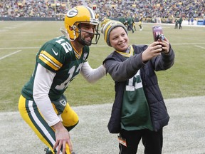 CORRECTS TO REMOVE SCORE- Simon McPhail takes a selfie with Green Bay Packers' Aaron Rodgers before an NFL football game against the Detroit Lions Sunday, Dec. 30, 2018, in Green Bay, Wis.