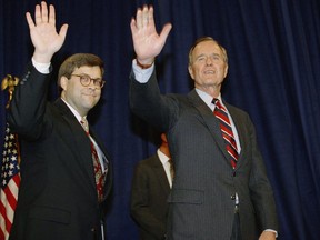 FILE - In this Nov. 26, 1991, file photo, President George H.W Bush, right, and William Barr wave after Barr was sworn in as the new Attorney General of the United States at a Justice Department ceremony in Washington. Barr, President Donald Trump's pick for attorney general, once questioned the effectiveness of a border wall similar to the one the president now wants to construct. Barr was attorney general under President George H.W. Bush when he was asked in a 1992 interview if he supported a proposal from Republican challenger Pat Buchanan to erect a barrier of ditches and fences along the Mexican border to stem the flow of illegal immigrants. Barr described a side-to-side barrier as "overkill."