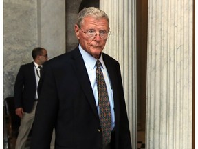 FILE - In this July 17, 2017, file photo, Sen. James Inhofe, R-Okla., leaves the Senate floor on Capitol Hill in Washington. Inhofe, the chairman of the Senate Armed Services Committee, quickly unloaded newly acquired Raytheon stock following a report that the purchase was made after he urged President Donald Trump to boost defense spending by billions of dollars.