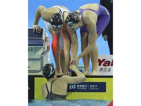 Members of the USA team celebrate after breaking the world record at the women 4x50m medley relay during the 14th FINA World Swimming Championships in Hangzhou, China Wednesday, Dec. 12, 2018. USA broke the world record with a time of 1:42.38