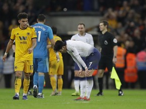 Tottenham Hotspur's Son Heung-min, bends down after the end of the English Premier League soccer match between Tottenham Hotspur and Wolverhampton Wanderers, as Wolverhampton Wanderers Morgan Gibbs-White walks past at Wembley stadium in London, Saturday, Dec. 29, 2018. Wolves won the game 3-1.