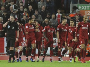 Liverpool's Roberto Firmino, (at centre, No 9) celebrates with teammates after scoring his sides 1st goal during the English Premier League soccer match between Liverpool and Arsenal at Anfield in Liverpool, England, Saturday, Dec. 29, 2018.