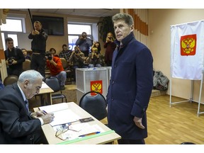 Oleg Kozhemyako, acting governor of the far eastern region of Primorsky Krai stands as he waits to get his ballot at a polling station in Vladivostok, Russia, Sunday, Dec. 16, 2018. Russians living in the far eastern region of Primorsky Krai cast their votes Sunday for a new governor in a tightly watched election, with Kozhemyako reported to be leading the vote.