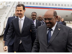 In this photo released by the Syrian official news agency SANA, Syrian President Bashar Assad, left, meets with Sudan's President Omar al-Bashir in Damascus, Syria, Sunday, Dec. 16, 2018 in Damascus. Sudan's president has become the first Arab League leader to visit Syria since a war erupted there nearly eight years ago. Omar al-Bashir was greeted at the Damascus airport Sunday by Syrian President Bashar Assad. Syria was expelled from the 22-member Arab League soon after war broke out in 2011. (SANA via AP)