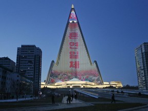 In this Dec. 20, 2018, photo, a propaganda message is displayed on the facade of the pyramid-shaped Ryugyong Hotel in Pyongyang, North Korea. Transformed into the backdrop for a gargantuan propaganda display, the capital city's yet-to-be-completed 105-story Ryugyong Hotel is once again the talk of North Korea. In a brilliant flip of the script, the uninhabited, pyramid-like building that towers over the North's capital has been festooned with more than 100,000 lights that for several hours every night flash propaganda far and wide.