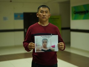 In this photo taken Dec. 7, 2018, Mussa Imamadiuly, a truck driver, stands with a picture of his wife's little brother for a photo outside the office of an advocacy group for ethnic Kazakhs born in China in Almaty, Kazakhstan on Imamadiuly says shortly after his marriage, his new wife's little brother was arrested and taken to an internment camp. Last month, they heard through relatives still in China that police had notified them that his wife's little brother was about to be transferred to a factory.