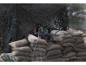 In this Thursday, Dec. 13, 2018 photo, a Lebanese soldier takes his position at the site where Israeli excavators work, in the southern border village of Mays al-Jabal, Lebanon. As Israeli excavators dig into the rocky ground, Lebanese across the frontier gather to watch what Israel calls the Northern Shield operation aimed at destroying attack tunnels built by Hezbollah. But Lebanese soldiers in new camouflaged posts, behind sandbags, or inside abandoned homes underscore the real anxiety that any misstep could lead to a conflagration between the two enemy states that no one seems to want.