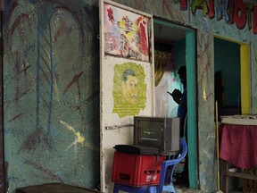 A hairdresser waits for customers in Kinshasa, Congo, Friday Dec. 28, 2018.  Congo's leader Joseph Kabila has blamed a deadly Ebola virus outbreak for the last-minute decision to keep an estimated 1 million voters from the polls in Sunday's long-delayed presidential election.