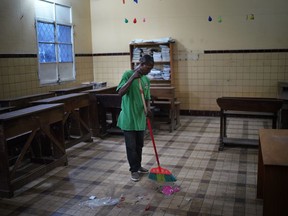 A cleaner sweeps the floors of a school classroom being prepared as a polling station in Kinshasa, Congo, Saturday Dec. 29, 2018.  Congolese people are heading to the polls Sunday Dec. 30th for a presidential race plagued by years of delay and persistent rumours of lack of preparation.