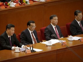 Chinese President Xi Jinping, left, speaks during a conference to commemorate the 40th anniversary of China's Reform and Opening Up policy at the Great Hall of the People in Beijing, Tuesday, Dec. 18, 2018.