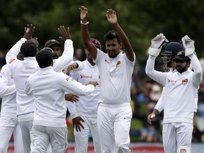 Sri Lanka's Suranga Lakmal, second right, is congratulated by teammates after taking the wicket of New Zealand's Tom Latham during play on day one of the second cricket test between New Zealand and Sri Lanka at Hagley Oval in Christchurch, New Zealand, Wednesday, Dec. 26, 2018.