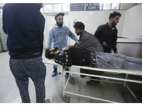 Kashmiri men wheel in an injured civilian on a stretcher inside a hospital in Srinagar, Indian controlled Kashmir, Saturday, Dec. 15, 2018. At least seven civilians were killed and nearly two dozens injured when government forces fired at anti-India protesters in disputed Kashmir following a gunbattle that left three rebels and a soldier dead on Saturday, police and residents said.