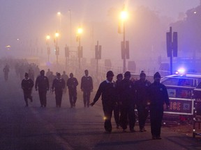 In this Wednesday, Dec. 26, 2018, photo, Indian military personals walk amidst morning smog in New Delhi, India. Authorities have ordered fire services to sprinkle water from high rise building to settle dust particles and stop burning of garbage and building activity in the Indian capital as the air quality hovered between severe and very poor this week posing a serious health hazard for millions of people.