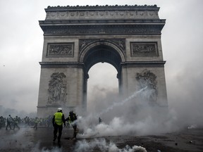 Demonstrators clash with riot police at the Arc de Triomphe during a protest of Yellow vests (Gilets jaunes) against rising oil prices and living costs, on December 1, 2018 in Paris.