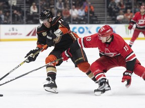 Anaheim Ducks right wing Daniel Sprong, left, and Carolina Hurricanes left wing Warren Foegele compete for the puck during the first period of an NHL hockey game in Anaheim, Calif., Friday, Dec. 7, 2018.