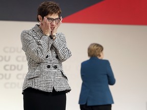 Newly elected CDU chairwoman Annegret Kramp-Karrenbauer, left, reacts during the party convention of the Christian Democratic Party in Hamburg, Germany, Friday, Dec. 7, 2018, after German Chancellor Angela Merkel, right, didn't run again for the party chairmanship.