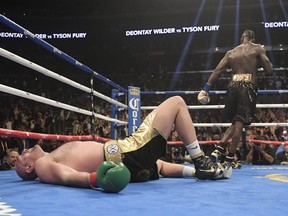 Tyson Fury of England lies on the canvas after being knocked down by Deontay Wilder during the 12th round of a WBC heavyweight championship boxing match Saturday, Dec. 1, 2018, in Los Angeles.