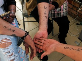 Central American migrants show the numbers to ask the US for political marked in their arms at the Migrant's House (Casa del Migrante) in Ciudad Juarez, Chihuahua state, Mexico, on November 15, 2018, in El Paso, Texas.