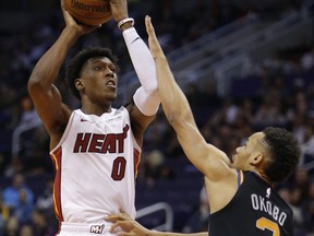 Miami Heat guard Josh Richardson (0) shoots over Phoenix Suns guard Elie Okobo during the first half of an NBA basketball game Friday, Dec. 7, 2018, in Phoenix.