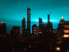 Buildings stand as the night sky is illuminated by blue light in New York on Dec. 27, 2018.