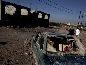 A boy sits in a car damaged during the conflict in Yemen, in a photo taken on Feb. 10, 2018.