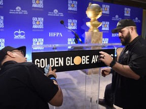 John Langhammer, left, and Brian Cooper, of Crews Unlimited II, set up the podium prior to the announcements of the nominations for the 76th Annual Golden Globe Awards at the Beverly Hilton hotel on Thursday, Dec. 6, 2018, in Beverly Hills, Calif. The 76th annual Golden Globe Awards will be held on Sunday, Jan. 6, 2019.