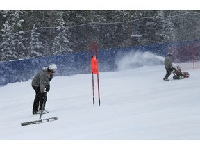 Workers prepare the course as it snows before a scheduled Men's World Cup super-G skiing race Saturday, Dec. 1, 2018, in Beaver Creek, Colo.