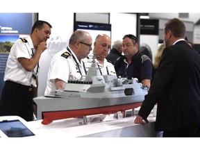 People surround a Bae Systems Type 26 Global Combat Ship at the Canadian Association of Defence and Security Industries CANSEC trade show in Ottawa on Wednesday, May 30, 2018.