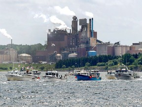 Fishing boats pass the Northern Pulp mill as concerned residents, fishermen and Indigenous groups protest the mill's plan to dump millions of litres of effluent daily into the Northumberland Strait in Pictou, N.S., on Friday, July 6, 2018. Northern Pulp says it is taking legal action after fishermen blocked survey boats hired to examine a route for a contentious undersea effluent pipeline.