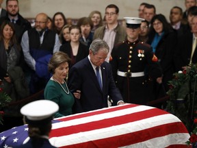 Former President George W. Bush and former first lady Laura Bush pause in front of the flag-draped casket of former President George H.W. Bush as he lies in state in the Capitol's Rotunda in Washington, Tuesday, Dec. 4, 2018. Liberal cabinet minister Scott Brison and ambassador David MacNaughton will join former prime minister Brian Mulroney in representing Canada at today's state funeral for former U.S. president George H.W. Bush.