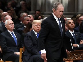 Former President George W. Bush walks past President Donald Trump and former President Barack Obama to speak a State Funeral for President George H.W. Bush, at the National Cathedral, Wednesday, Dec. 5, 2018, in Washington.