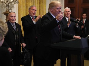 President Donald Trump makes the thumbs up sign as he speaks during a Hanukkah reception, Thursday, Dec. 6, 2018, in the East Room of the White House in Washington. At right is Vice President Mike Pence.