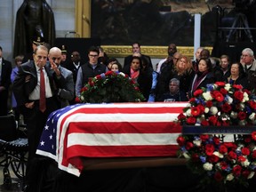 Former Sen. Bob Dole salutes the flag-draped casket containing the remains of former President George H.W. Bush as he lies in state at the U.S. Capitol in Washington, Tuesday, Dec. 4, 2018.