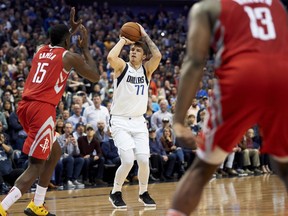 Dallas Mavericks forward Luka Doncic (77) shoots a 3-pointer over Houston Rockets center Clint Capela (15) during the second half of an NBA basketball game, Saturday, Dec. 8, 2018, in Dallas.