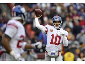 New York Giants quarterback Eli Manning (10) throws to New York Giants running back Saquon Barkley, left, during the first half of an NFL football game against the Washington Redskins, Sunday, Dec. 9, 2018, in Landover, Md.