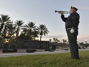 Beaches Honor Guard bugler John Poe plays Taps in honor of former President George H.W. Bush on the day of his funeral Thursday, Dec. 6, 2018 at the Veteran's Memorial Wall at TIAA Bank Field in Jacksonville, Fla. Hundreds of buglers across the country played Taps at the time of his internment.