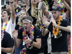Central Florida students wearing Hawaiian leis cheer before start of the American Athletic Conference championship NCAA college football game between Central Florida and Memphis, Saturday, Dec. 1, 2018, in Orlando, Fla. Over 40,000 leis were distributed to fans before the game to show support for injured quarterback McKenzie Milton who is from Hawaii.