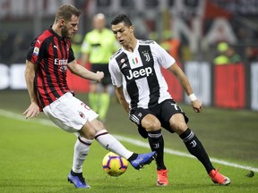 FILE - In this Sunday, Nov. 11, 2018 file photo, AC Milan's Ignazio Abate , left, and Juventus' Cristiano Ronaldo fight for the ball during a Serie A soccer match between AC Milan and Juventus, at Milan's San Siro stadium, Italy. Serie A has announced details of the Italian Super Cup to be played in Saudi Arabia next month despite calls for the game to be moved after the killing of Washington Post columnist Jamal Khashoggi. The match between Juventus and AC Milan is slated to be played Jan. 16 at the King Abdullah Sports City Stadium in Jeddah.