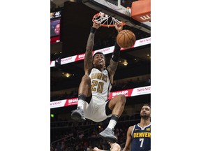 Atlanta Hawks forward John Collins (20) dunks against the Denver Nuggets during the first half of an NBA basketball game Saturday, Dec. 8, 2018, in Atlanta.