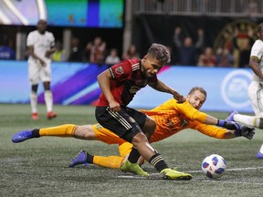 Atlanta United forward Josef Martinez (7) beats Portland Timbers goalkeeper Jeff Attinella (1) to score a goal during the first half of the MLS Cup championship soccer game, Saturday, Dec. 8, 2018, in Atlanta.