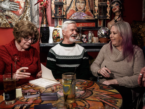 Adrian Pearce, centre, his wife Jan Piers, left, and his ex girlfriend Vicki Allen sign books for fans in St. Albert, Alberta., on Dec. 6, 2018.