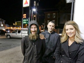 In this Nov. 17, 2017, file photo, Johnny Bobbitt Jr., left, Kate McClure, right, and McClure's boyfriend Mark D'Amico pose at a Citgo station in Philadelphia.  A New Jersey prosecutor was set to announce developments Thursday, Nov. 15, 2018, in a criminal investigation of  the couple that raised $400,000 for Bobbitt Jr, a homeless man they said helped them with a disabled car.