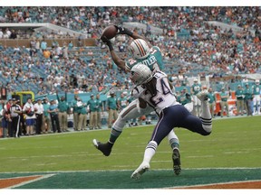 Miami Dolphins wide receiver Brice Butler (14) catches a pass for a touchdown over New England Patriots cornerback Stephon Gilmore (24), during the second half of an NFL football game, Sunday, Dec. 9, 2018, in Miami Gardens, Fla.