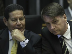 In this Nov. 6, 2018 file photo, Brazilian President-elect Jair Bolsonaro, right, and his Vice President, Gen. Hamilton Mourao, attend a ceremony marking the 30th anniversary of Brazil's constitution at Congress in Brasilia, Brazil.