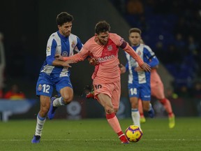 FC Barcelona's Lionel Messi, center, controls the ball during the Spanish La Liga soccer match between Espanyol and FC Barcelona at RCDE stadium in Cornella Llobregat, Spain, Saturday, Dec. 8, 2018.