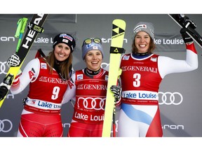 Austria's Nicole Schmidhofer, centre, celebrates her victory with second place finisher Cornelia Huetter, left, also of Austria, and third place finisher Switzerland's Michelle Gisin following the women's World Cup downhill ski race at Lake Louise, Alta., Saturday, Dec. 1, 2018.
